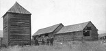 Fort Colvile. Bastion and building behind unidentified men.